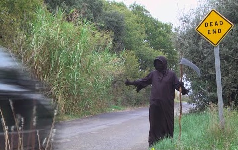 Grim reaper standing at side of road