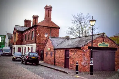 Photo of brick building and cars on a Stourbridge road