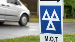 A car drives past a sign for an MOT testing centre