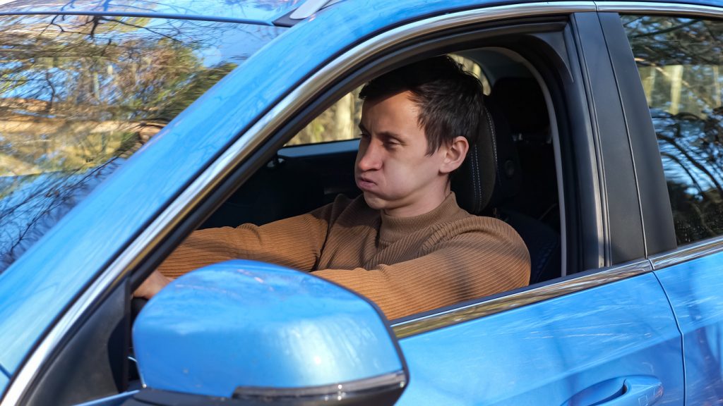 A frustrated driver puffs out his cheeks
