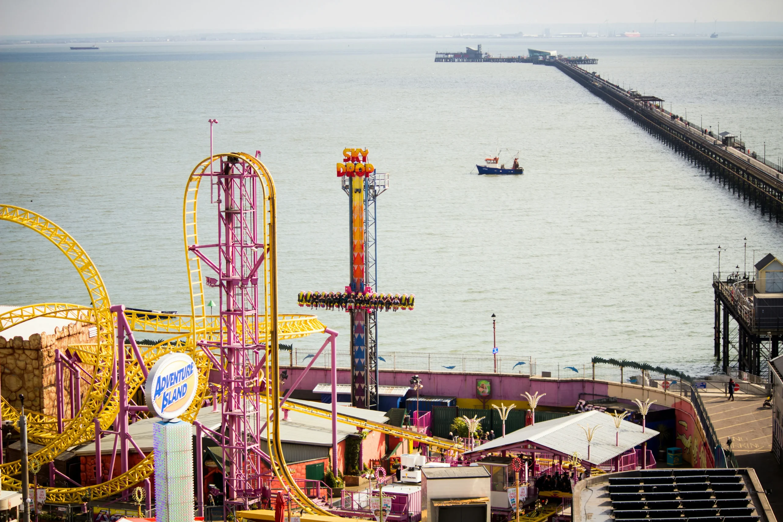 Southend pier, a boat on the water, and fairground in the foreground.