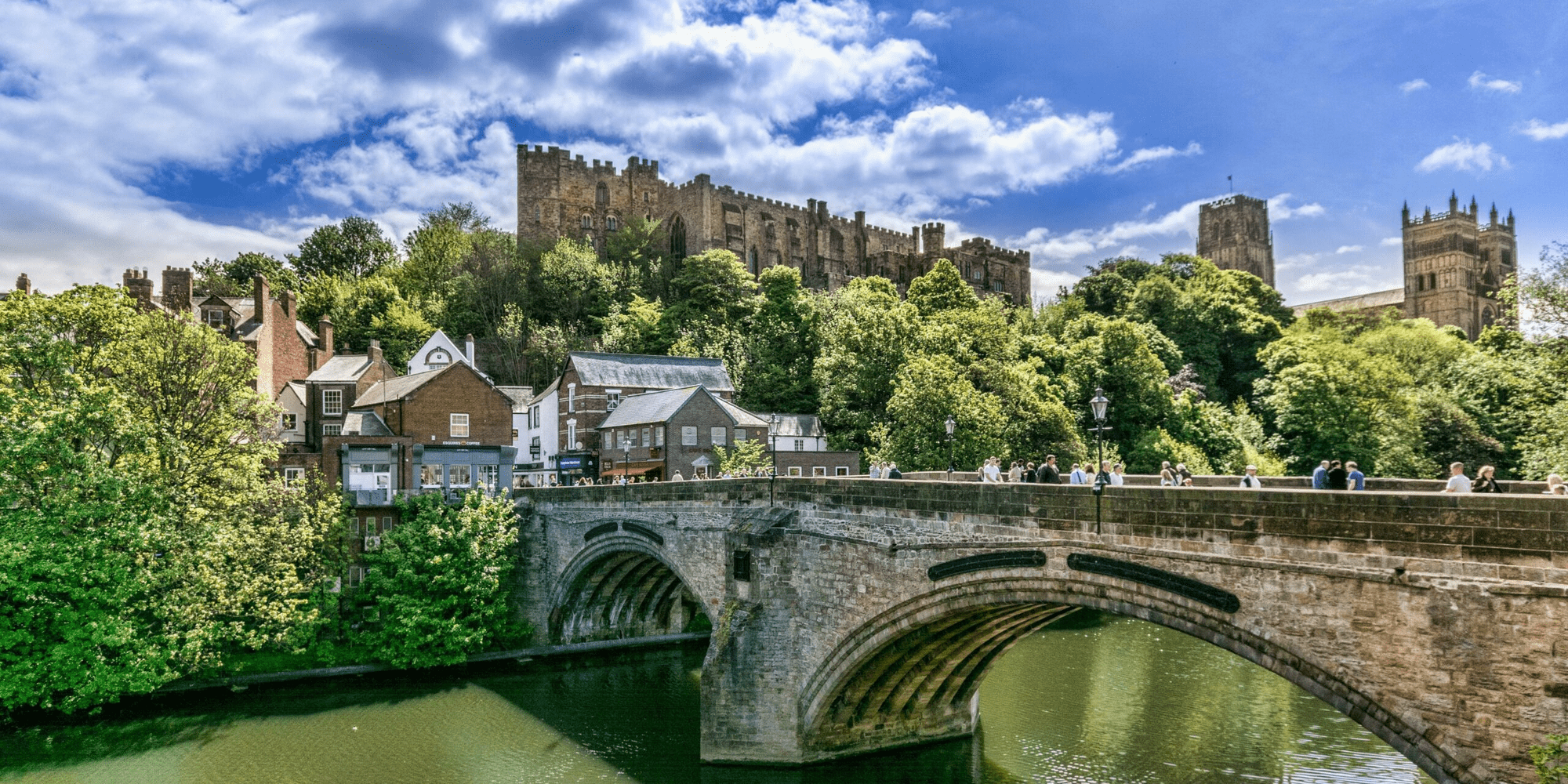 View in Durham over high street and town houses in the foreground and castle in the background