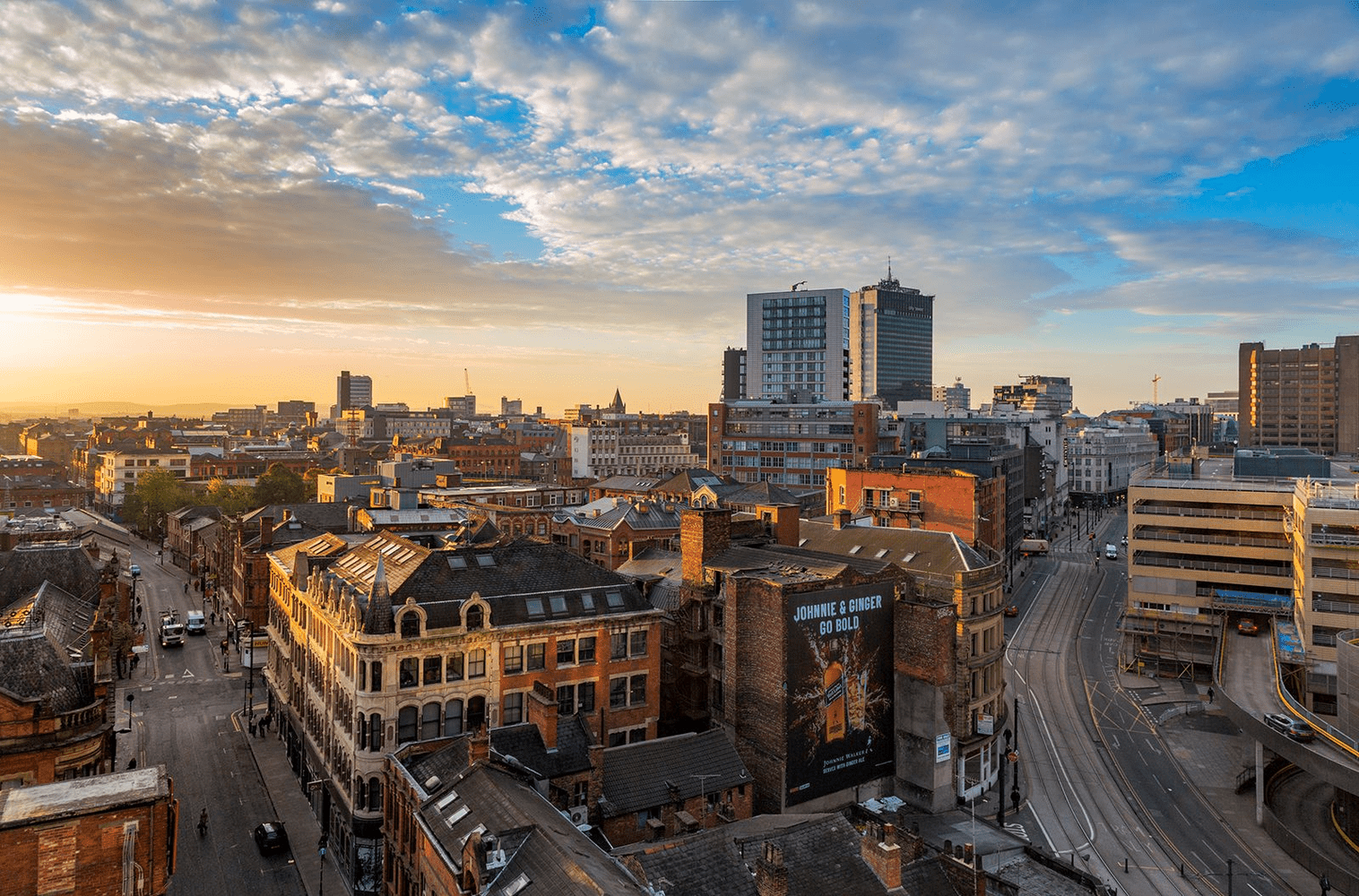 Manchester city landscape as the sun sets over the tall buildings