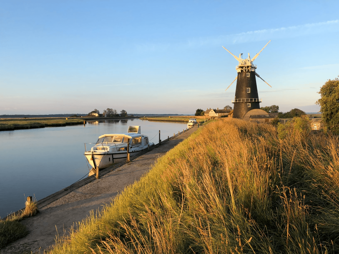 Norfolk Broads photo alongside the river with windmill in background