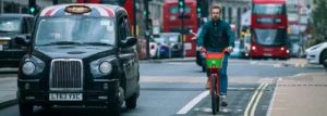 cyclist next to taxy on city street