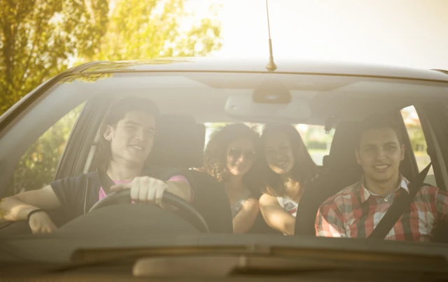 A group of young teens driving in the sunset