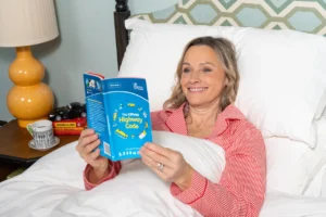 Vicki Butler-Henderson smiles while reading the Highway Code in bed