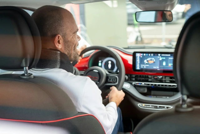 A man driving a car while looking at his touchscreen